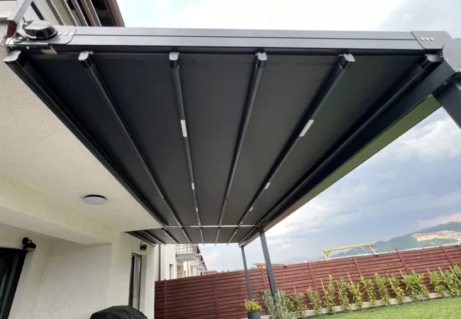 Pergole retractabile Ambisun instalate în curte la Brașov Pergole retractabile de calitate premium produsă de Ambisun în România, montate într-o curte modernă din Brașov, ideală pentru terase rezidențiale elegante