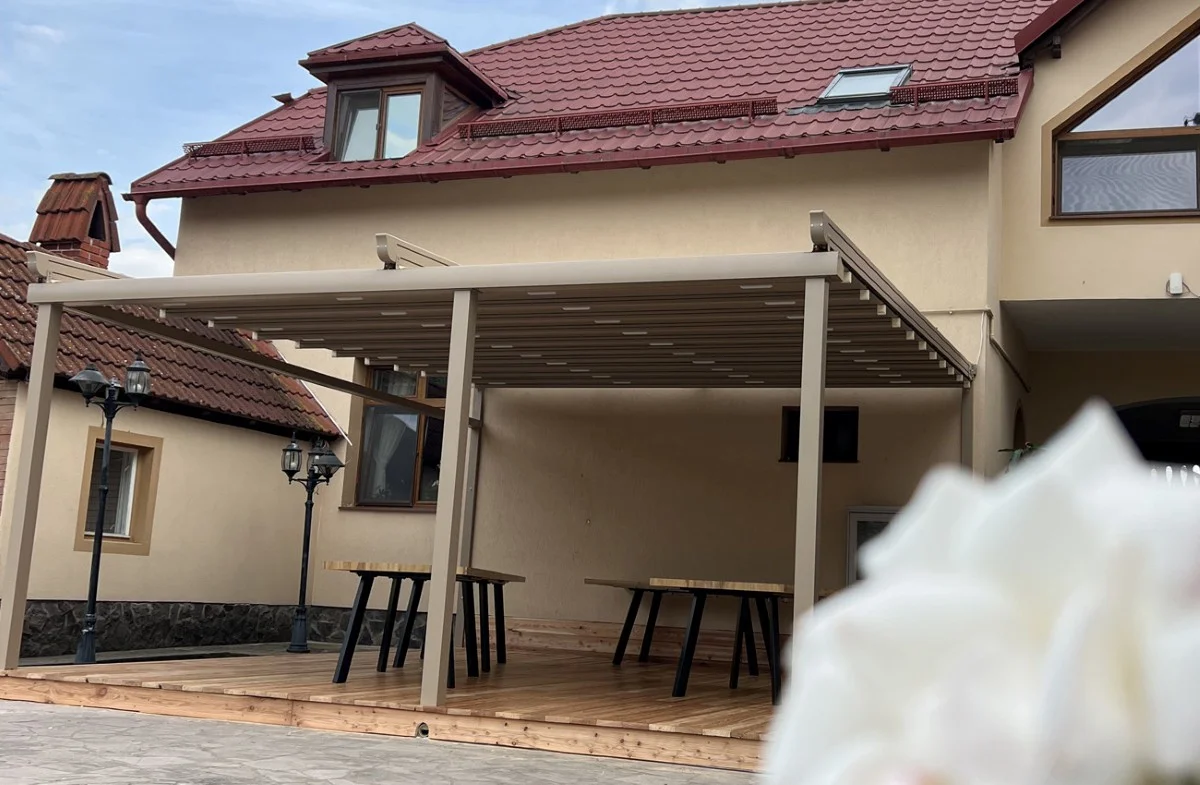 Pergolă retractabilă Supreme pentru terasă din lemn în Brașov Pergolă retractabilă Supreme instalată pe terasă din lemn, proiect Ambisun Brașov